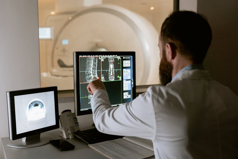 Medical professional reviewing MRI scans on computer screens for diagnostic purposes